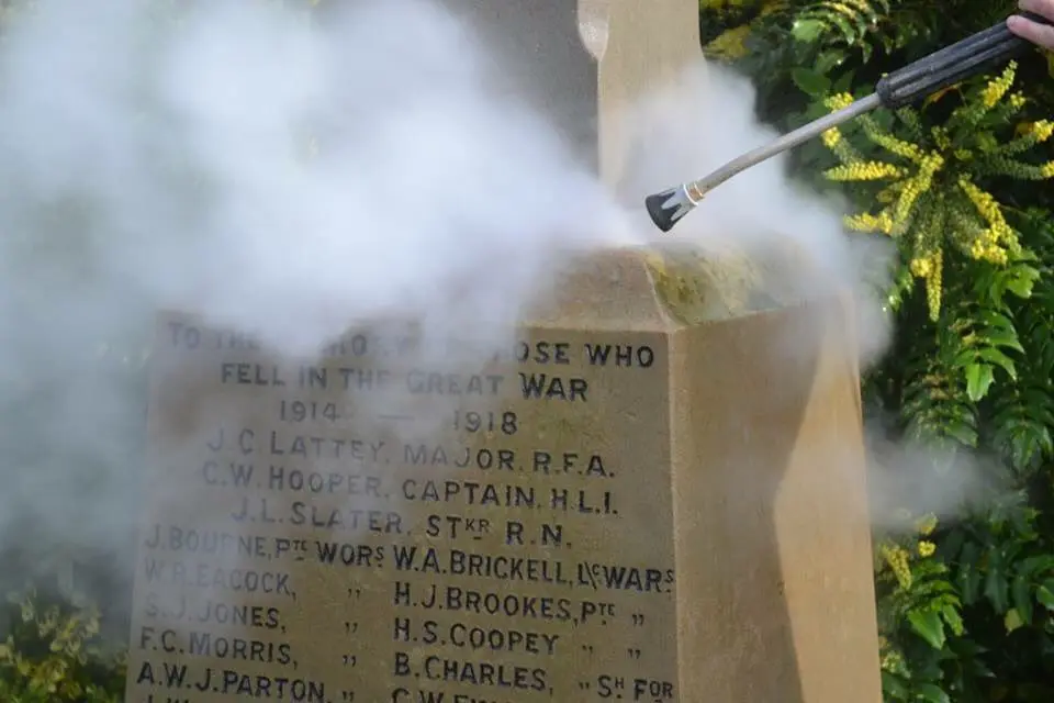 Pressure washing being used to clean monument